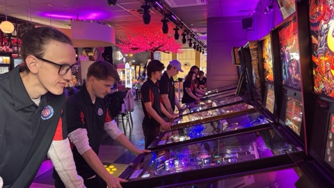 Guests playing pinball under the club lighting at The Flipside